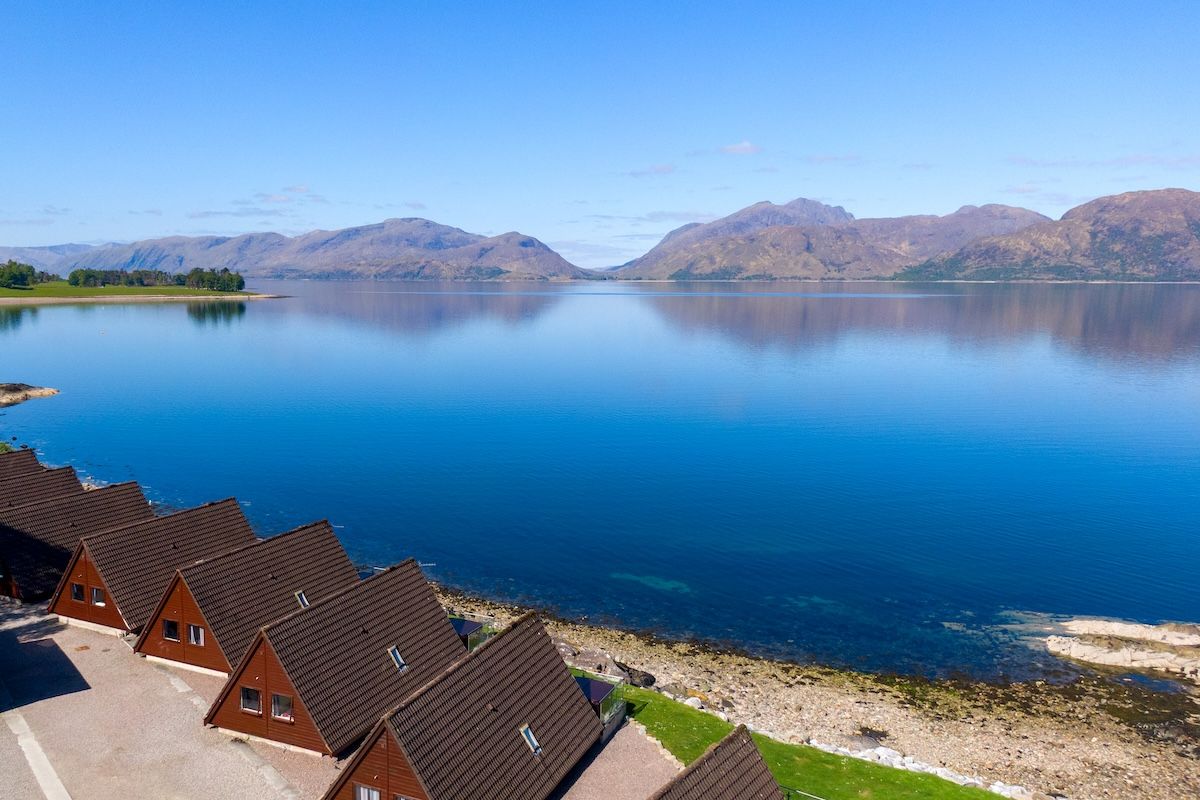 The lodges at the water's edge on a still day